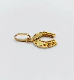 Pendentif vintage or jaune représentant un fer à cheval finement décoré